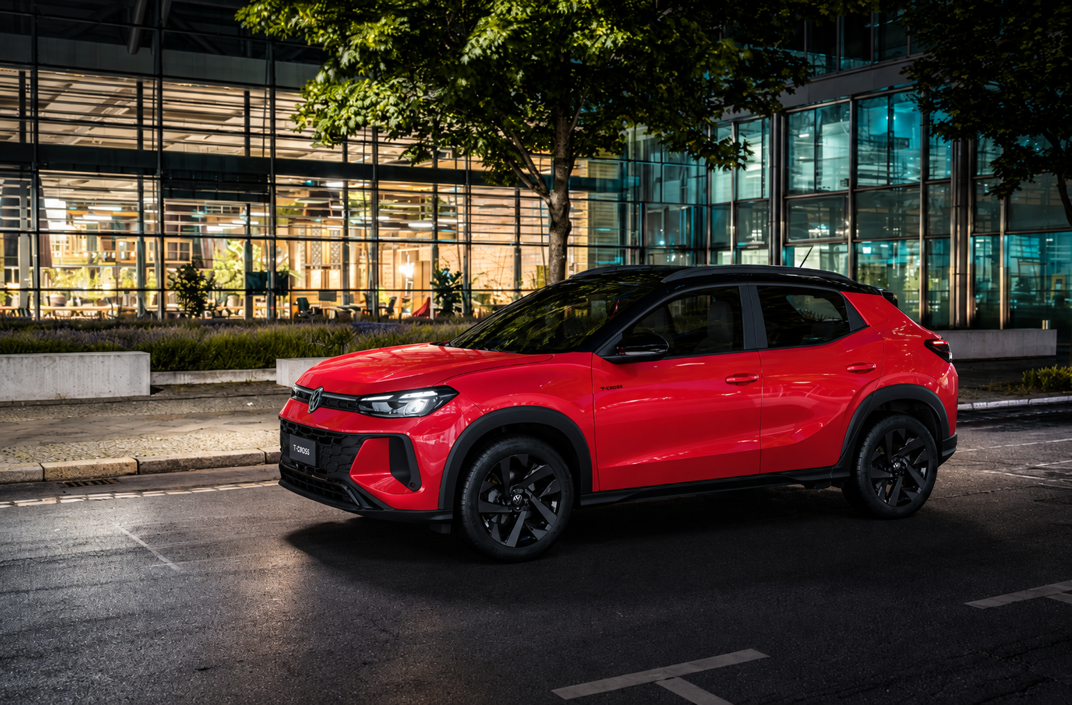 Volkswagen Tera 200 TSI vermelho visto de perfil em ambiente urbano, com teto preto, rodas escurecidas e faróis de LED acesos.