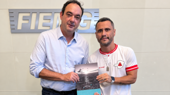 Flávio Roscoe, presidente da FIEMG, e Cleitinho Azevedo, governador eleito de Minas Gerais, seguram o documento Pacto por Minas 2026 na sede da Federação.