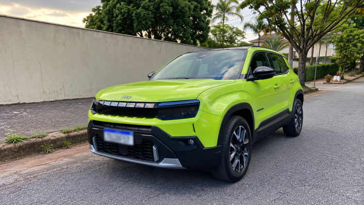 Jeep Avenger Longitude 2027 na cor verde vibrante, fotografado em ângulo frontal, destacando a grade de sete fendas, os faróis de LED, o para-choque robusto e as rodas de liga leve.