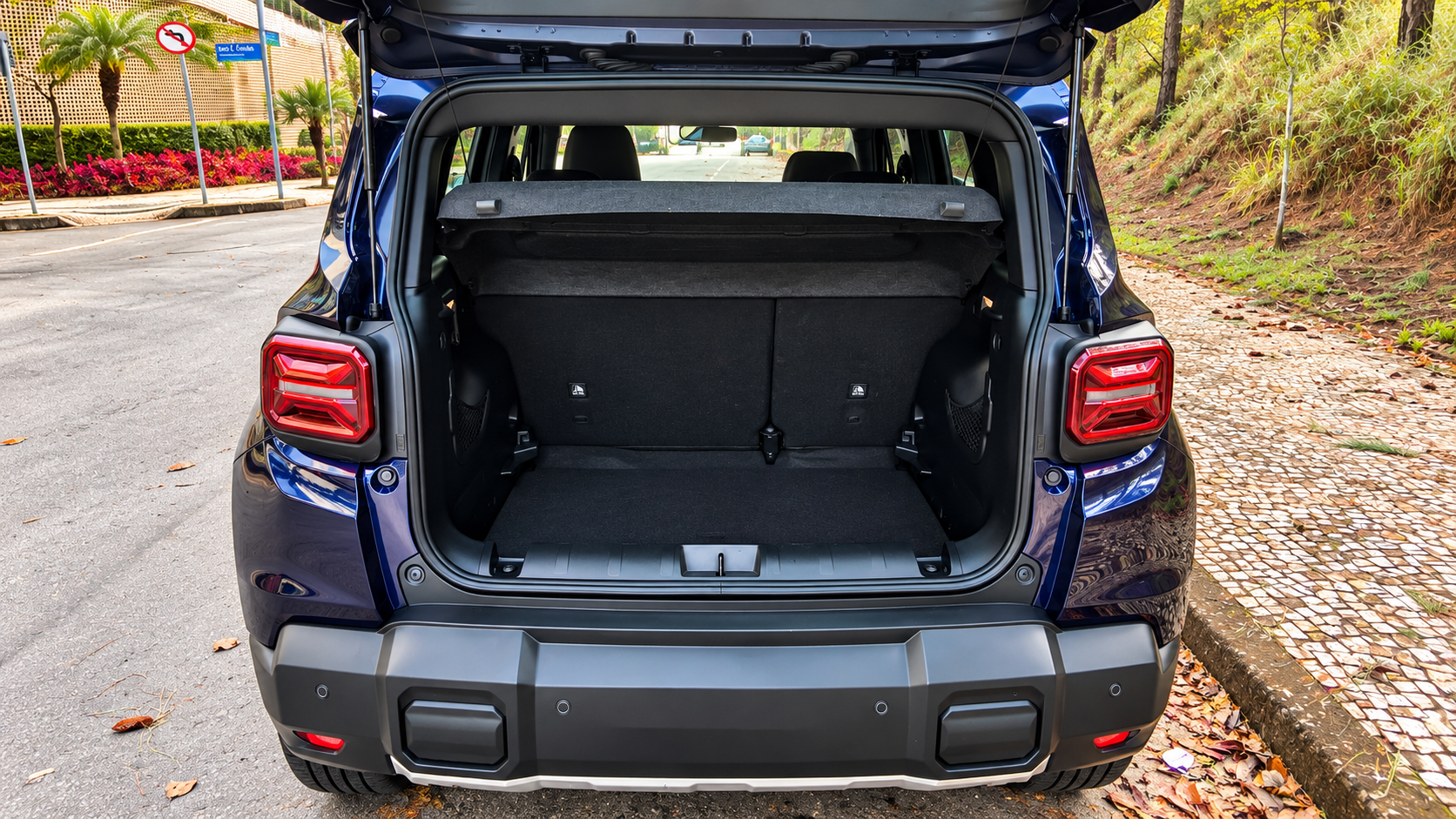 Porta-malas aberto do novo Jeep Renegade Longitude MHEV azul, mostrando o espaço de carga, revestimento interno, tampão removível e bancos traseiros.