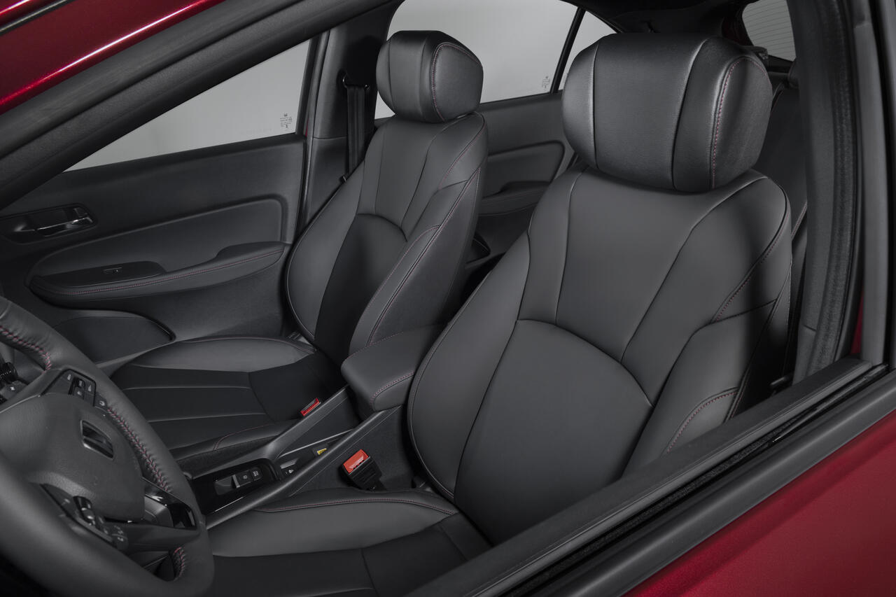 Bancos dianteiros do Honda City Hatchback RS 2027 com revestimento preto, costuras vermelhas esportivas, apoios de cabeça e acabamento refinado no interior.