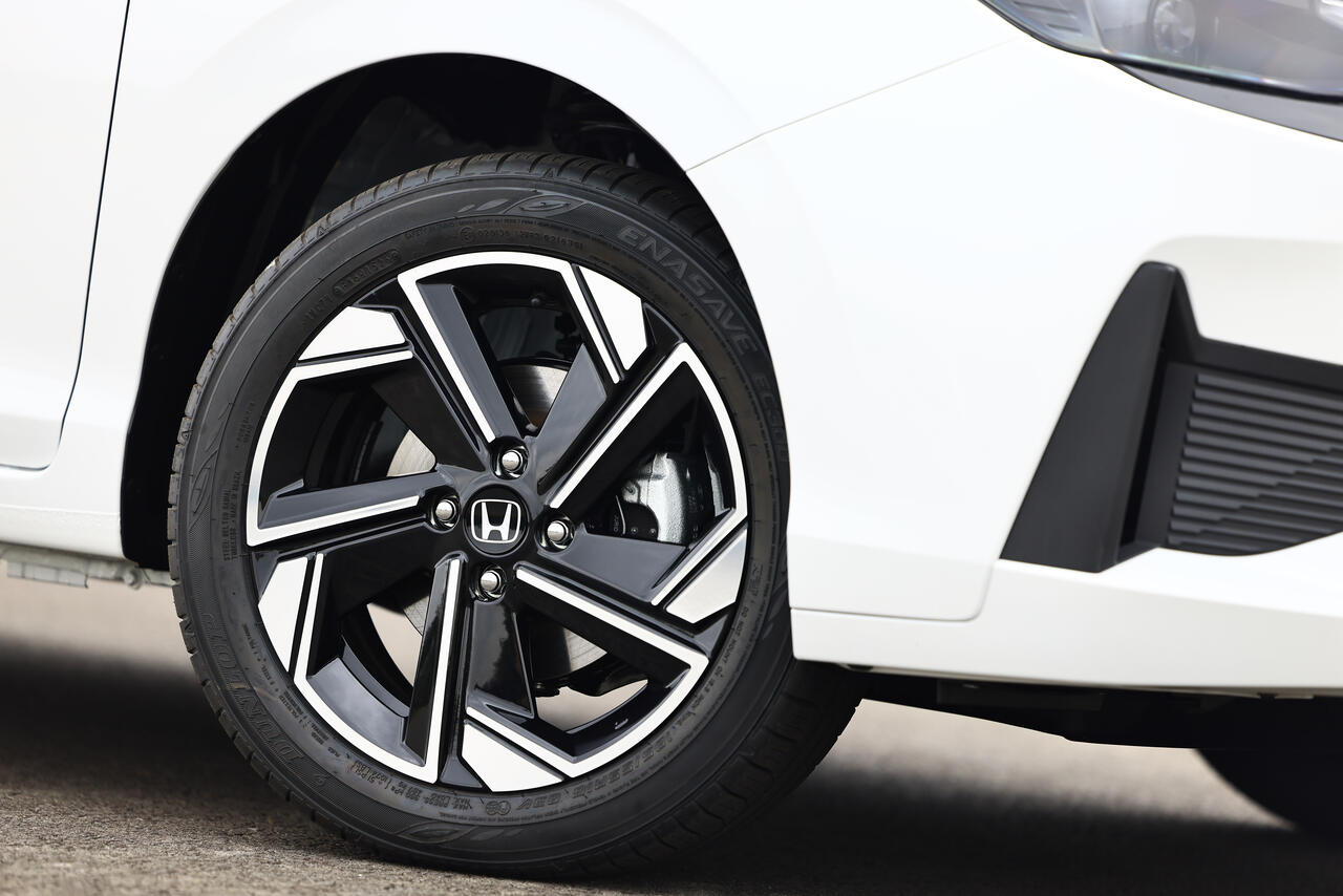 Detalhe da roda de liga leve aro 16 do Honda City 2027 branco, com acabamento diamantado em preto e prata, desenho esportivo e logotipo Honda centralizado.