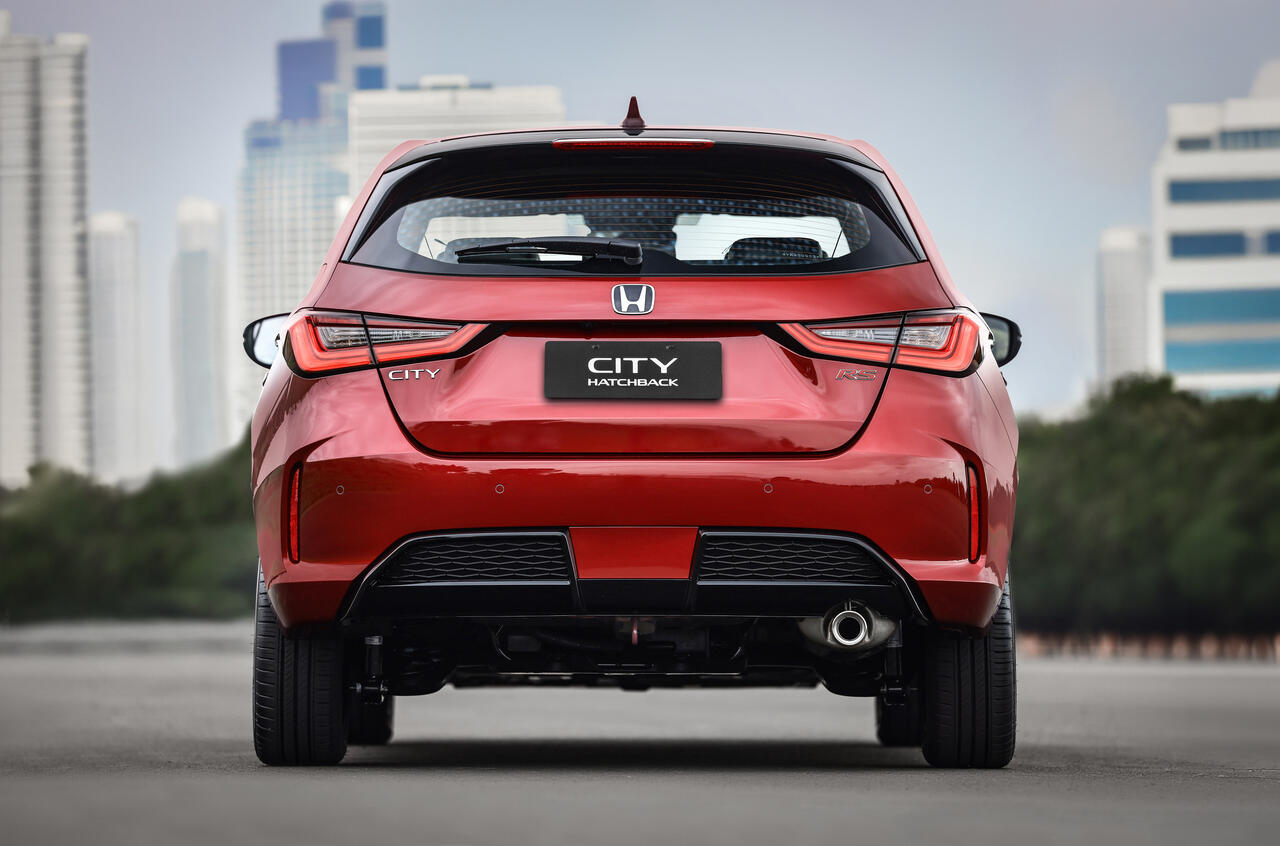 Vista traseira do Honda City Hatchback RS 2027 vermelho, destacando lanternas em LED, spoiler preto, para-choque esportivo, emblema RS e ponteira de escapamento cromada.